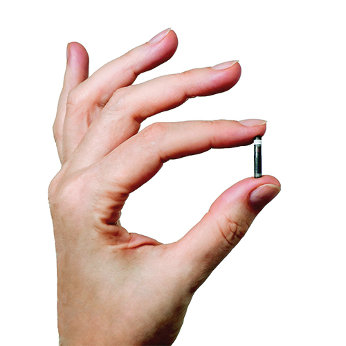 Dłoń trzymająca sensor glukozy Eversense E3.